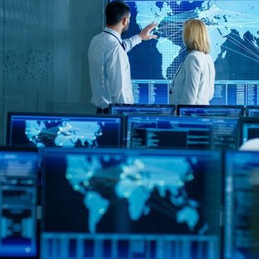 people working in a control room with monitors | security operations center