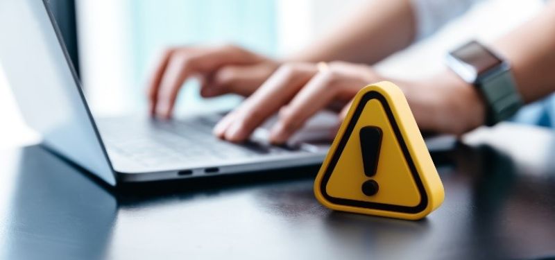 warning symbol next to a laptop
