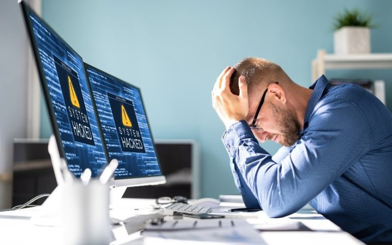 man frustrated in front of computer that was hacked 