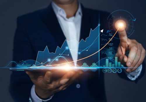 man holding up a digital image of a progress chart going up