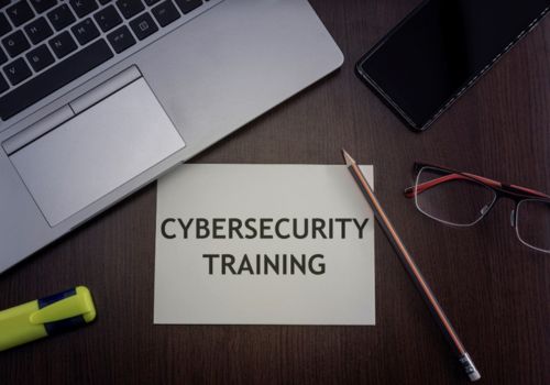 a sign that reads Cybersecurity training next to a laptop