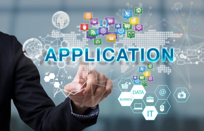 Image of a man's arm in a suit touching a screen with many different IT icons