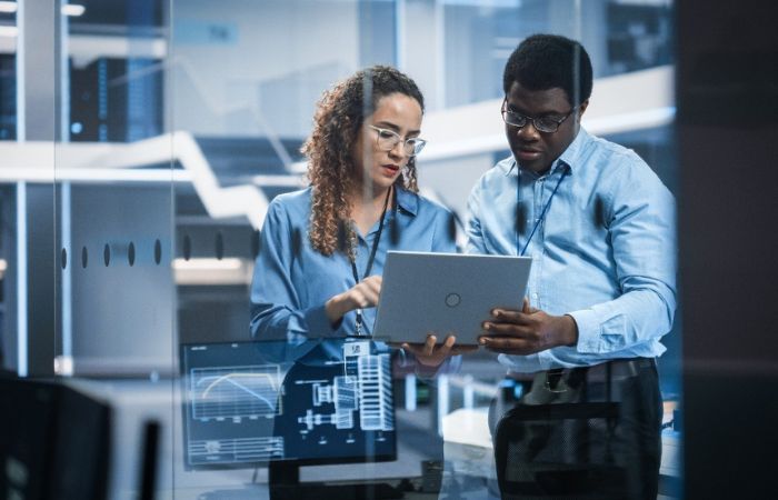male and female coworkers in a server room looking over its operations